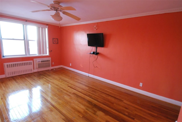 unfurnished room featuring crown molding, wood-type flooring, a wall mounted AC, radiator, and ceiling fan