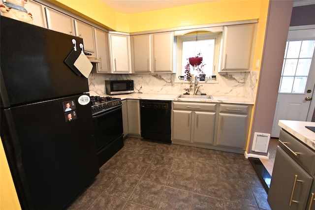 kitchen featuring backsplash, a wealth of natural light, sink, and black appliances