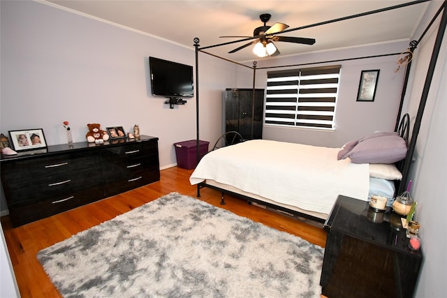 bedroom with crown molding, ceiling fan, and light wood-type flooring