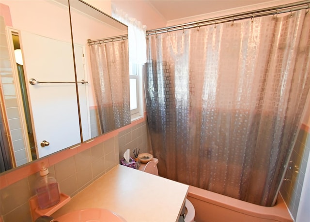 bathroom with tile walls, vanity, ornamental molding, and shower / bath combo