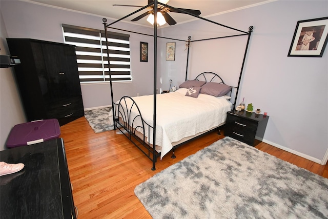 bedroom featuring hardwood / wood-style flooring, ornamental molding, and ceiling fan