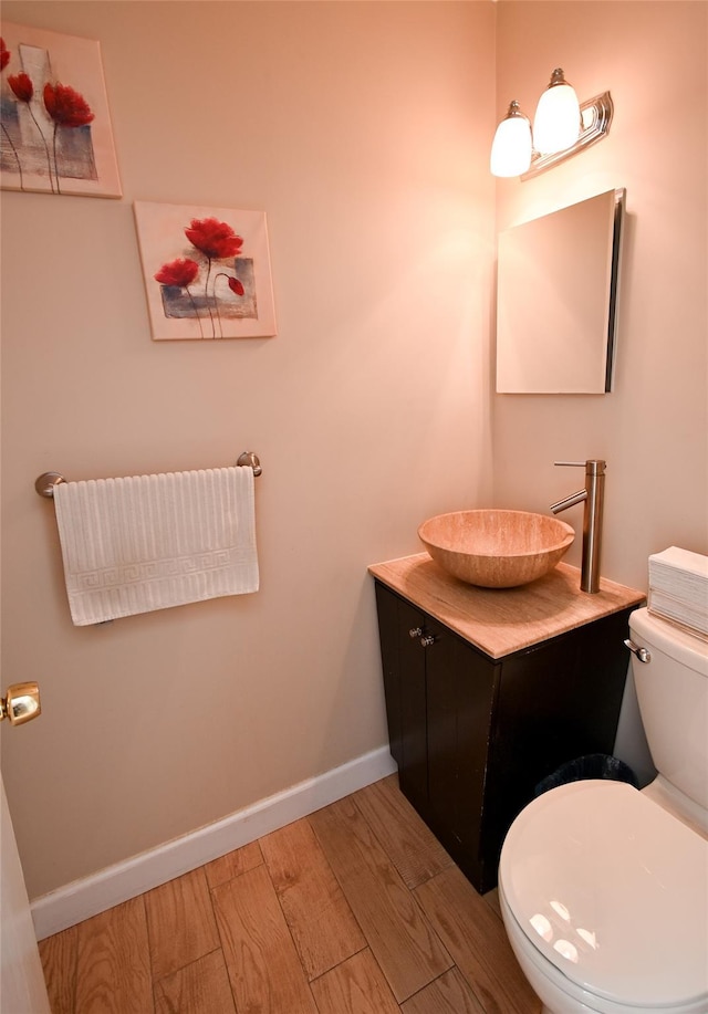 bathroom with vanity, wood-type flooring, and toilet