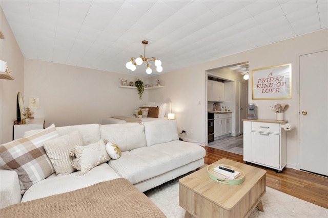 living room featuring a chandelier and light wood-type flooring