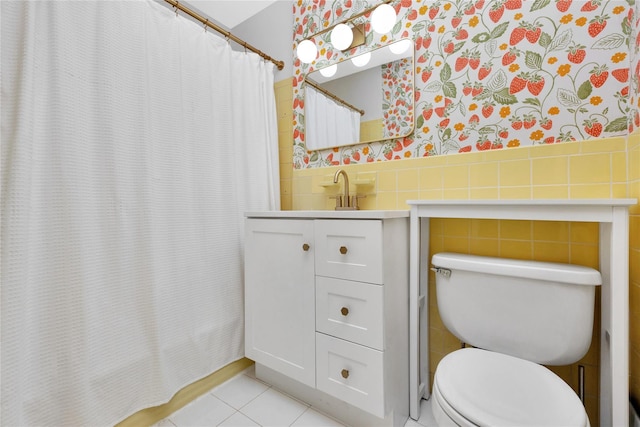 bathroom featuring vanity, toilet, tile patterned flooring, and tile walls