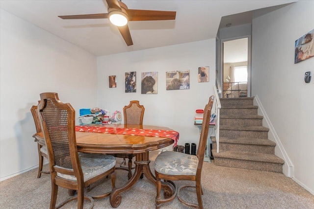 carpeted dining area with ceiling fan