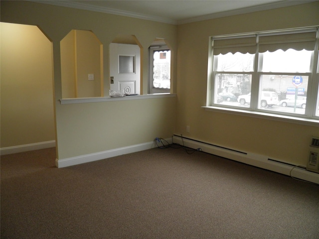 empty room featuring a healthy amount of sunlight, ornamental molding, carpet, and a baseboard heating unit