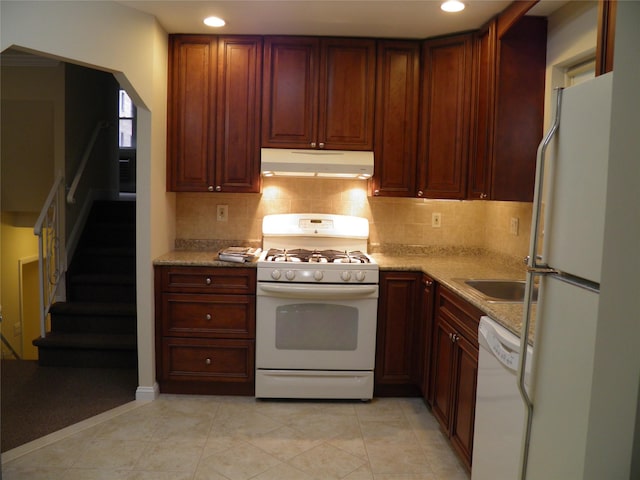 kitchen with sink, light stone counters, tasteful backsplash, light tile patterned floors, and white appliances