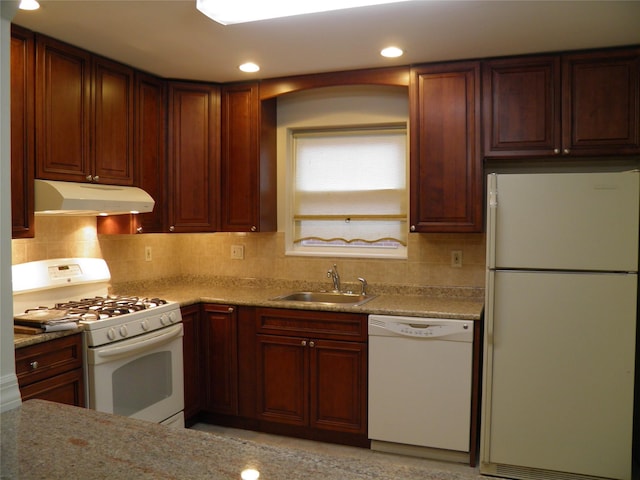 kitchen featuring tasteful backsplash, sink, white appliances, and light stone countertops