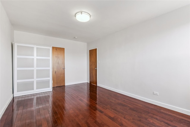 empty room with baseboards and dark wood finished floors