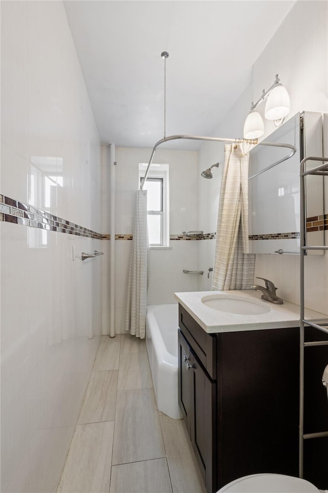 full bathroom with vanity, tile walls, and shower / tub combo with curtain