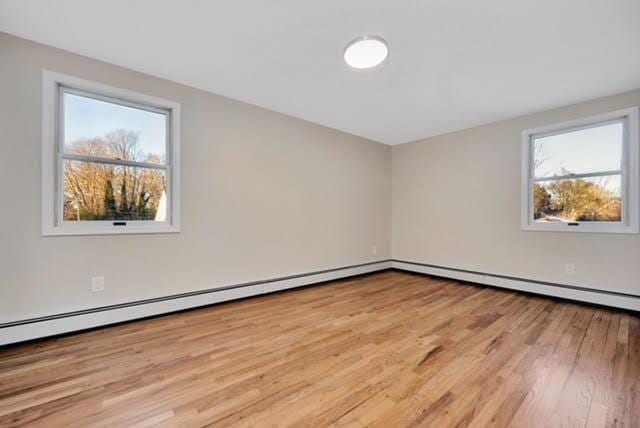 bonus room featuring a baseboard heating unit and light wood-type flooring