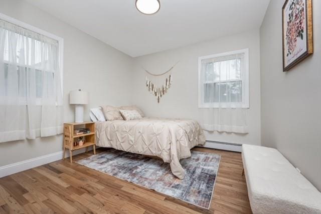 122 Vernon Valley Rd, East Northport, NY 11731 - bedroom with baseboard heating and wood finished floors