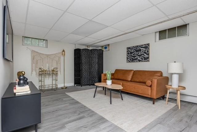 122 Vernon Valley Rd, East Northport, NY 11731 - living room with wood finished floors, a paneled ceiling, and a baseboard radiator