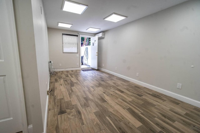 empty room featuring hardwood / wood-style flooring and a wall mounted AC