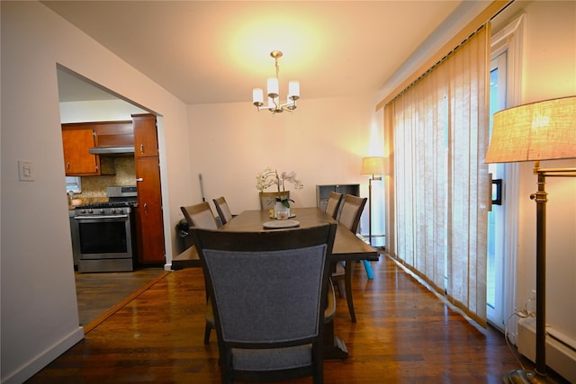 dining room featuring a baseboard heating unit, dark wood-type flooring, and a chandelier