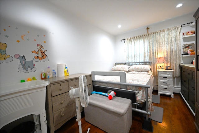 bedroom with a baseboard heating unit and dark wood-type flooring