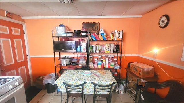 kitchen with white gas range and light tile patterned floors