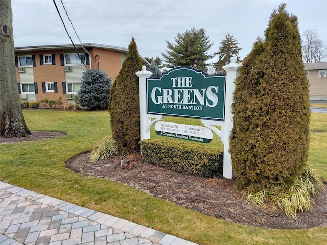 community / neighborhood sign featuring a lawn