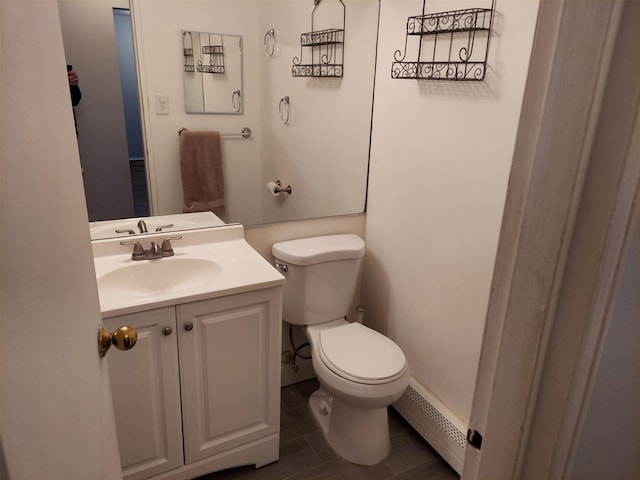 bathroom with vanity, a baseboard heating unit, tile patterned floors, and toilet