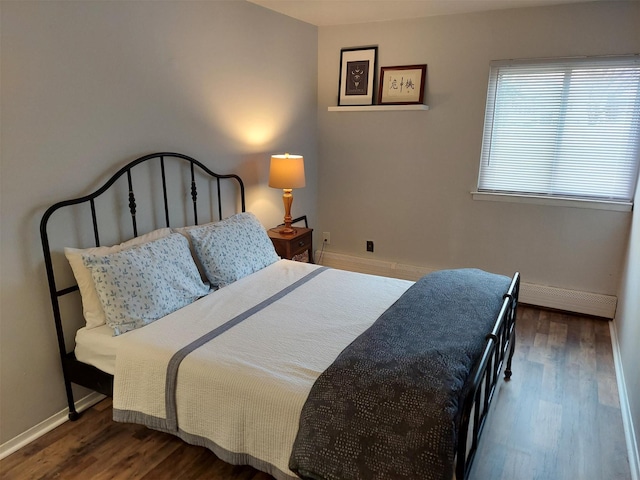 bedroom featuring dark wood-type flooring and baseboard heating