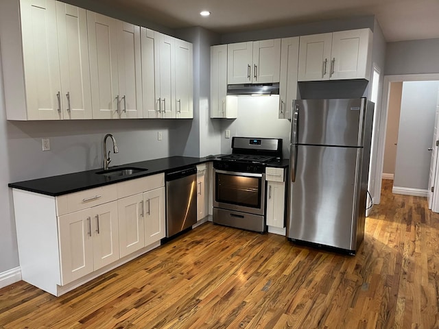 kitchen featuring white cabinetry, appliances with stainless steel finishes, sink, and wood-type flooring