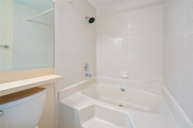 bathroom featuring tiled shower / bath combo and toilet