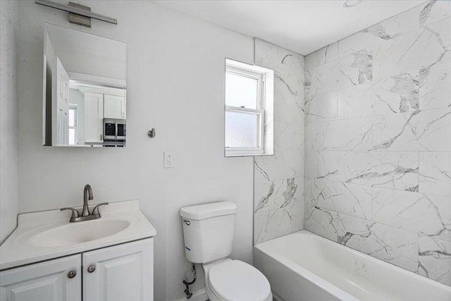 full bathroom with tiled shower / bath, vanity, and toilet