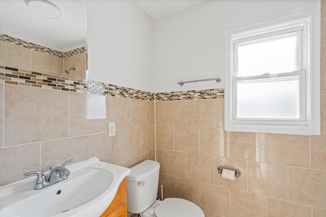 bathroom featuring vanity, tile walls, and toilet