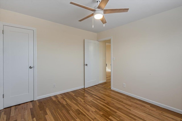 empty room with hardwood / wood-style flooring and ceiling fan