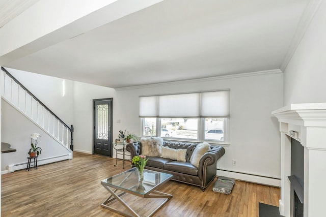 living room featuring hardwood / wood-style flooring, ornamental molding, and baseboard heating