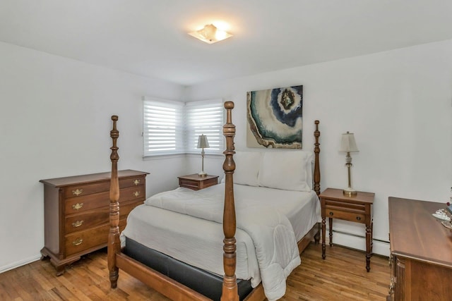 bedroom with light wood-type flooring and baseboard heating