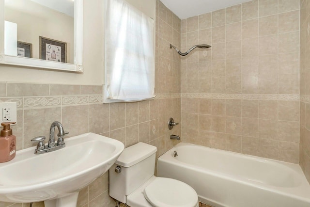 full bathroom featuring tiled shower / bath, tasteful backsplash, sink, tile walls, and toilet