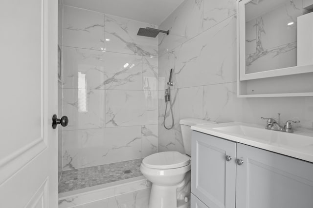 bathroom with vanity, a tile shower, and toilet