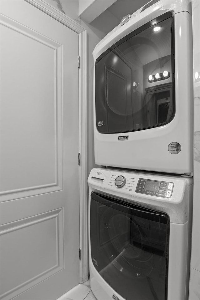 laundry area with stacked washing maching and dryer