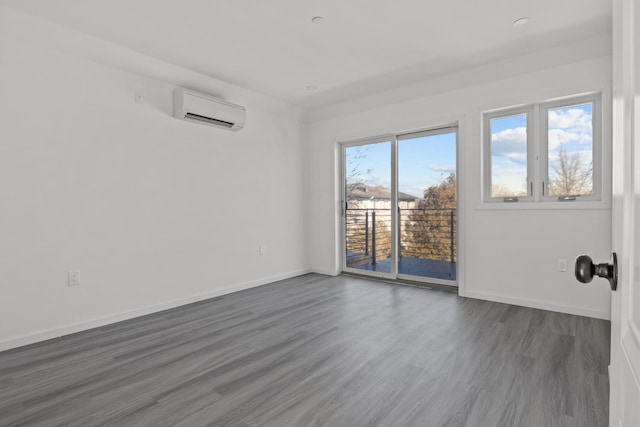 spare room featuring dark hardwood / wood-style flooring and a wall mounted air conditioner