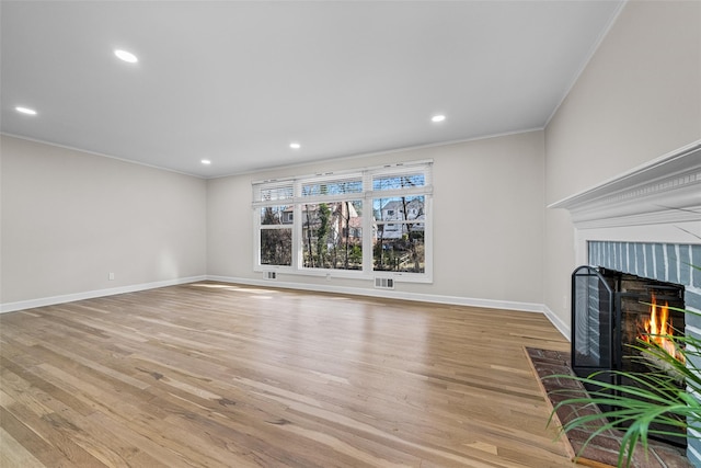 unfurnished living room featuring crown molding and light hardwood / wood-style flooring