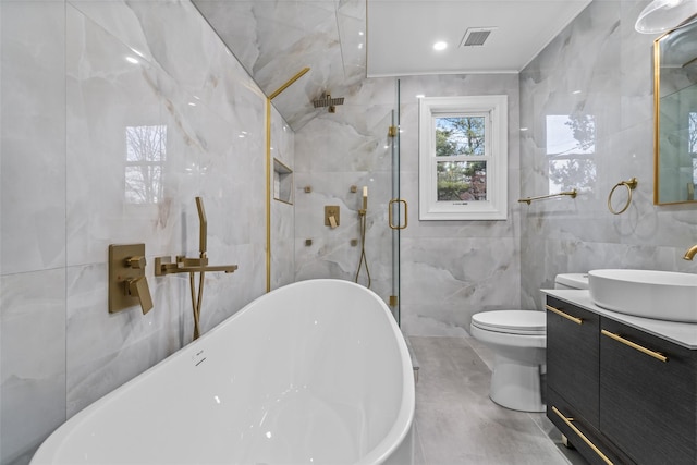 bathroom with vanity, toilet, a bathtub, and tile walls