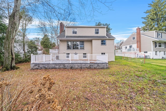 rear view of house featuring a yard, a deck, and central air condition unit