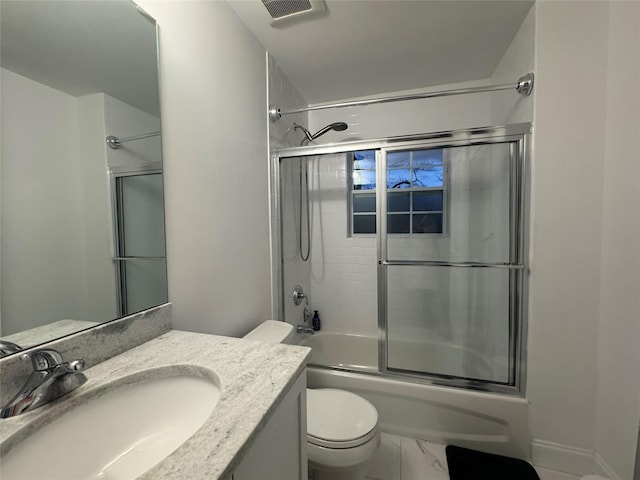 full bathroom with enclosed tub / shower combo, vanity, and toilet