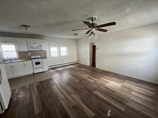 kitchen with hardwood / wood-style floors, tasteful backsplash, white cabinets, baseboard heating, and white appliances