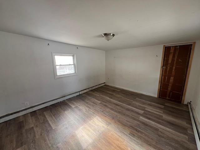 spare room featuring dark hardwood / wood-style flooring and baseboard heating