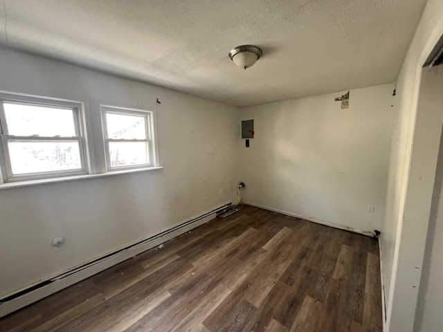 empty room with a baseboard radiator, dark hardwood / wood-style floors, electric panel, and a textured ceiling