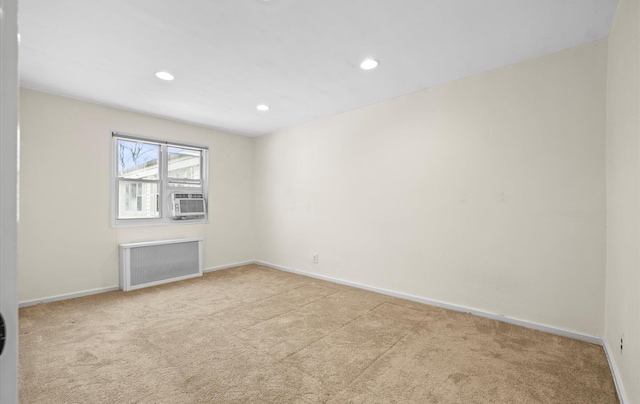 unfurnished room with light carpet, radiator, and cooling unit