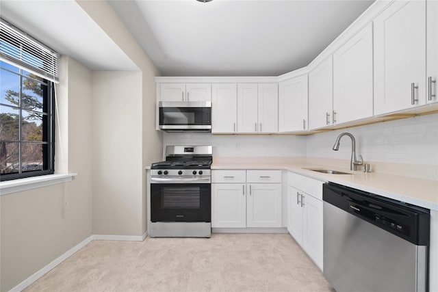 kitchen with white cabinetry, sink, backsplash, and stainless steel appliances