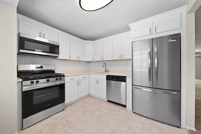 kitchen featuring sink, backsplash, white cabinets, and appliances with stainless steel finishes