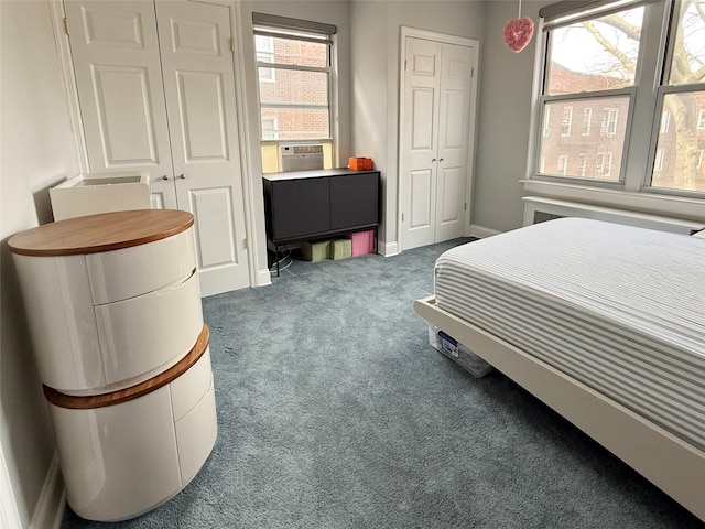 bedroom featuring multiple closets, carpet flooring, and cooling unit