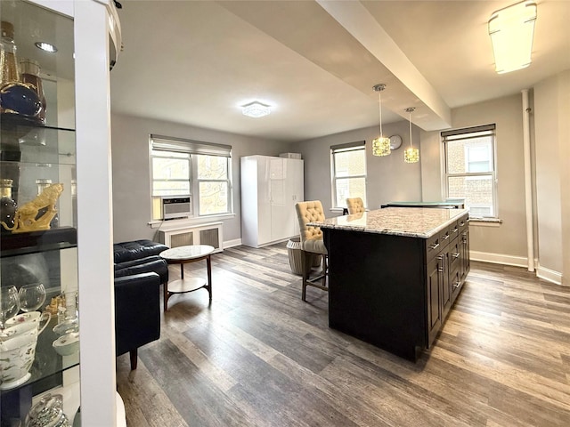 kitchen featuring dark hardwood / wood-style floors, pendant lighting, a kitchen breakfast bar, a center island, and dark brown cabinetry