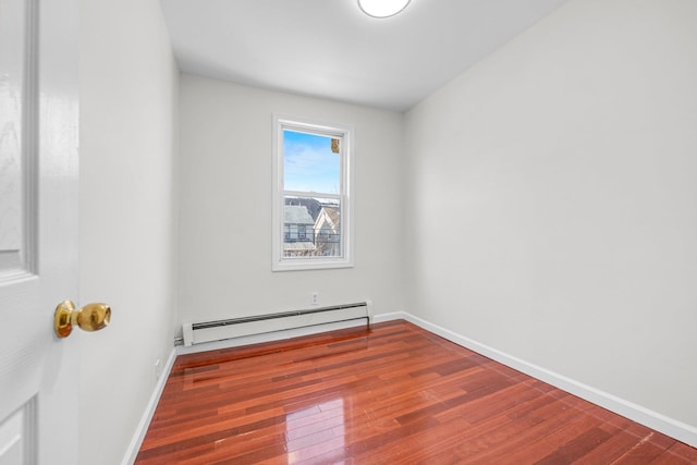 spare room featuring hardwood / wood-style flooring and a baseboard radiator