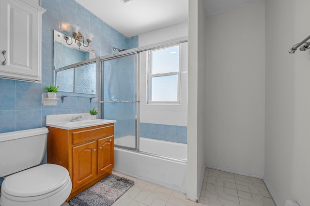 full bathroom with enclosed tub / shower combo, tile walls, vanity, and toilet