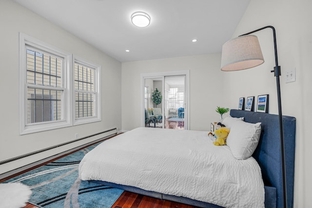 bedroom featuring dark wood-type flooring and a baseboard heating unit